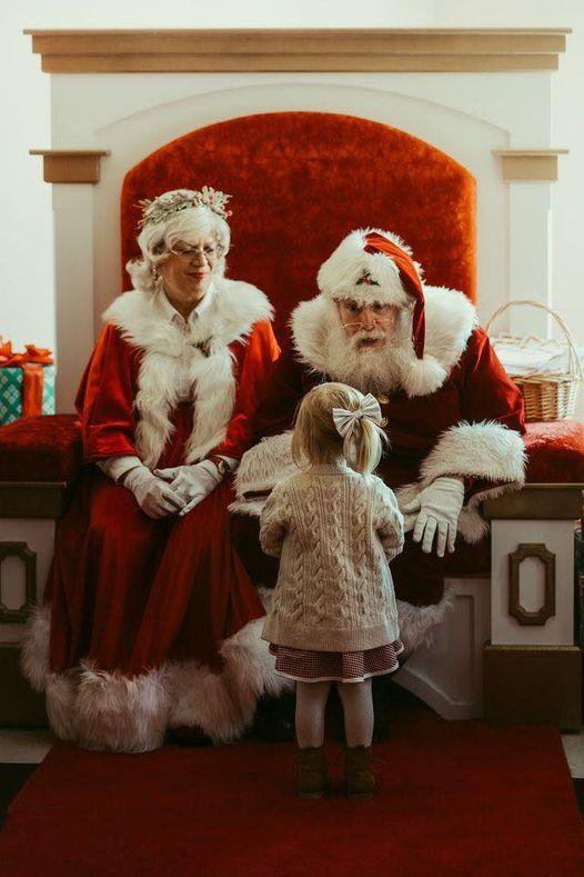 Santa and Mrs. Claus talking with a little girl